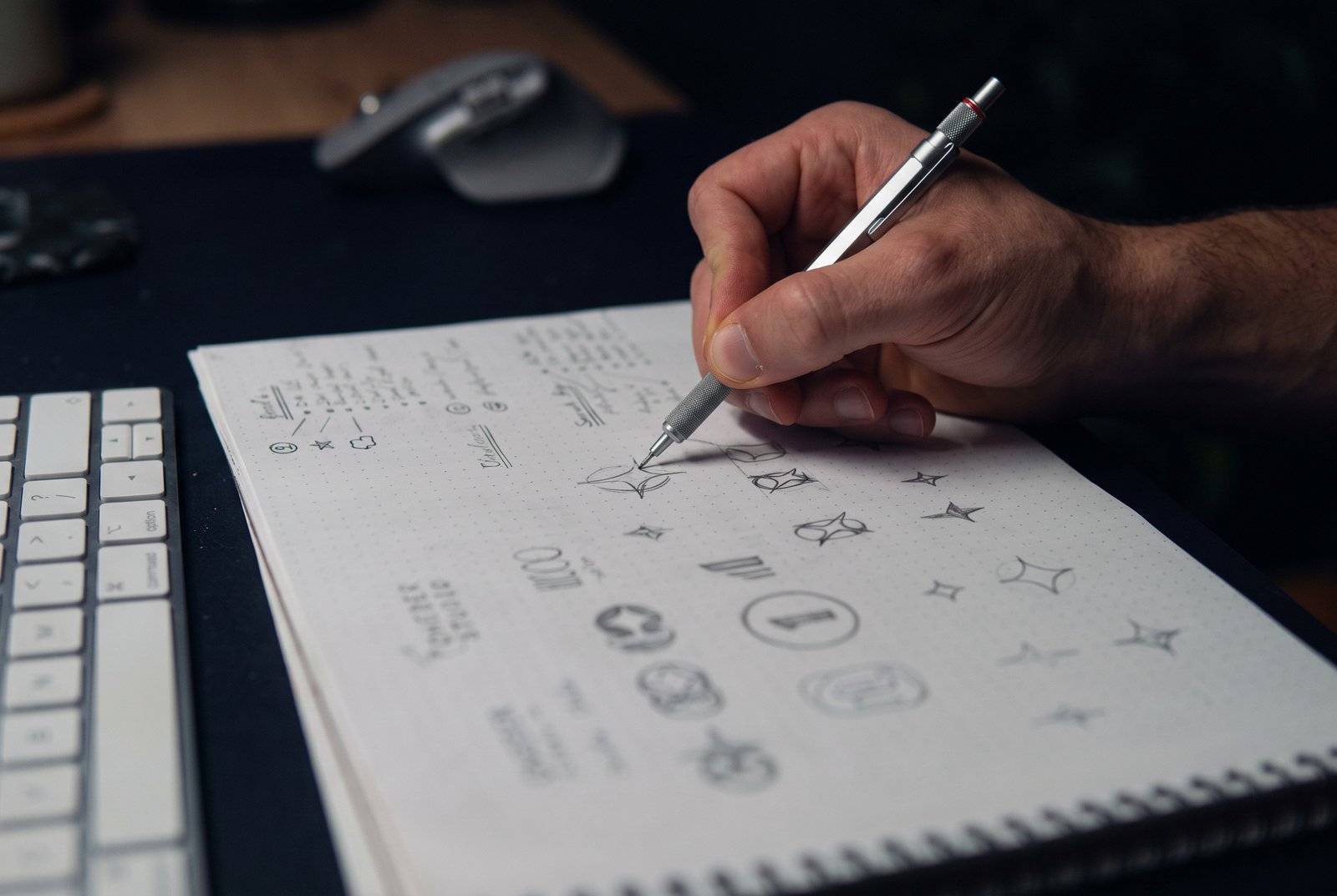 Designer desenhando estudos de logotipo em um caderno
